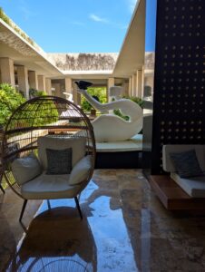 Modern resort lobby with egg chair and sculpture.