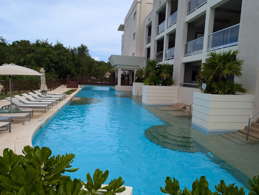 Luxurious swim-up rooms with private terraces leading directly into a sparkling pool, surrounded by tropical landscaping and lounge chairs