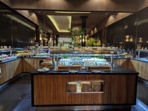 A lavish dessert buffet at an all-inclusive resort, featuring an array of cakes, pastries, and fresh fruit, elegantly displayed on a long table