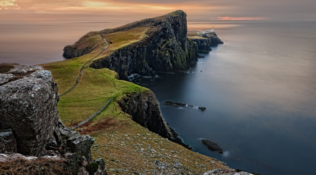A breathtaking sunset over the Isle of Skye, casting vibrant colors across the sky and reflecting on the tranquil waters.