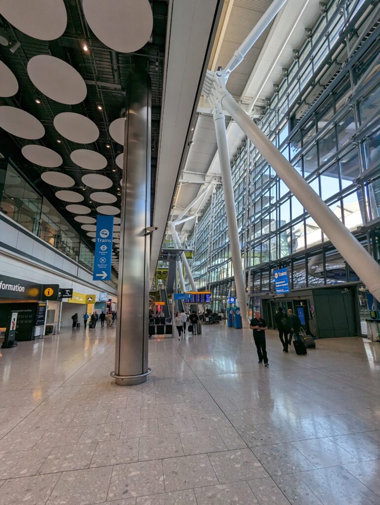 A bustling scene at London Heathrow Airport Terminal, showcasing travelers moving through the spacious concourse.