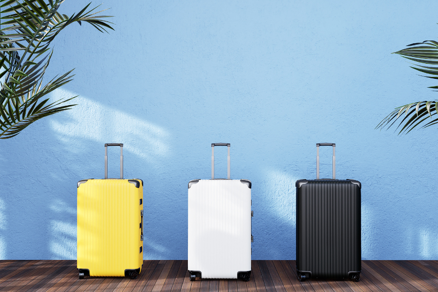 Three colorful suitcases in a line, ready for a travel adventure.