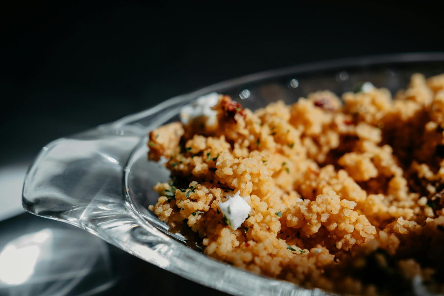 Close-up view of a vibrant couscous dish garnished with fresh herbs.