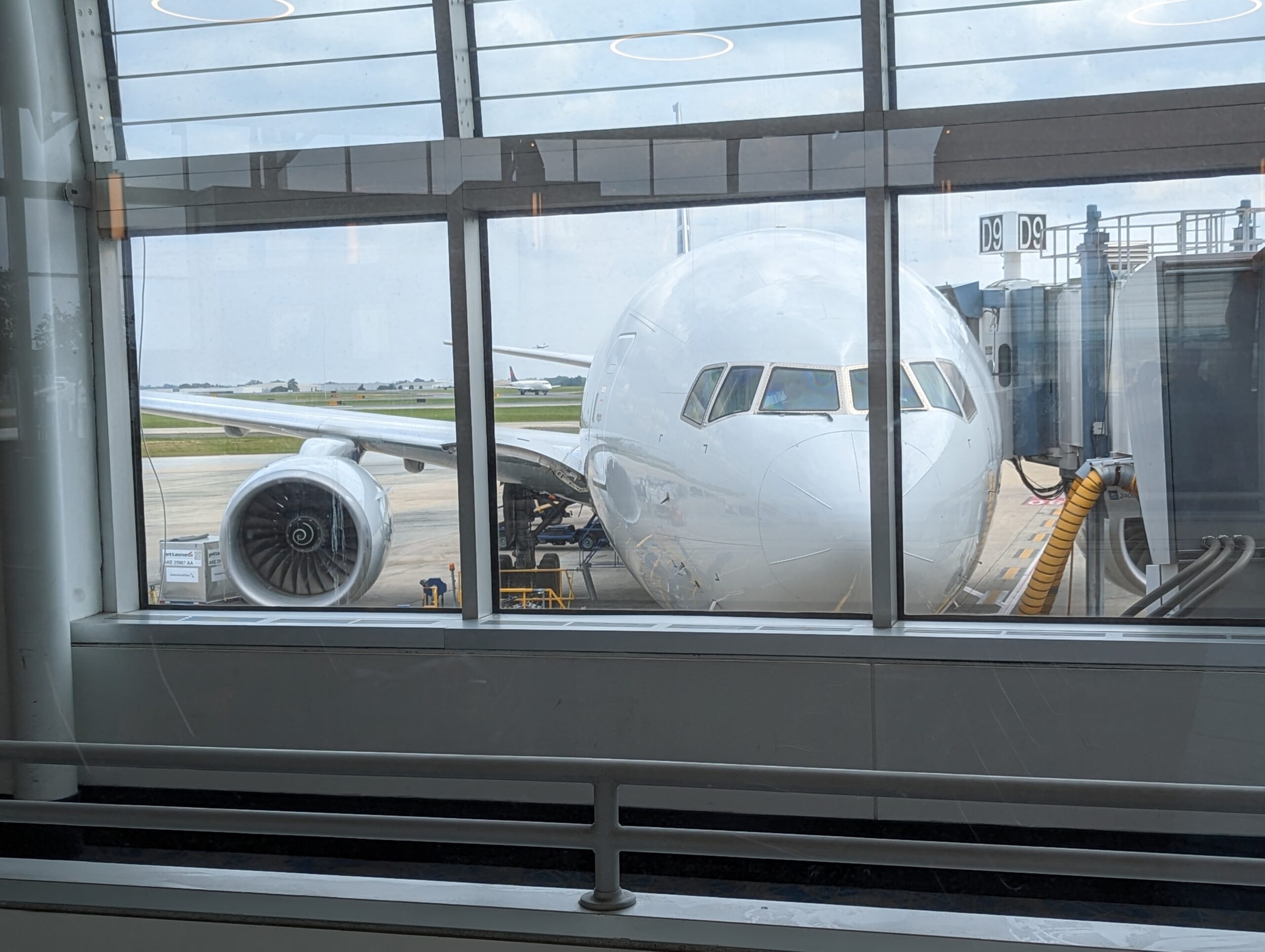 View of an airplane through a large airport window.